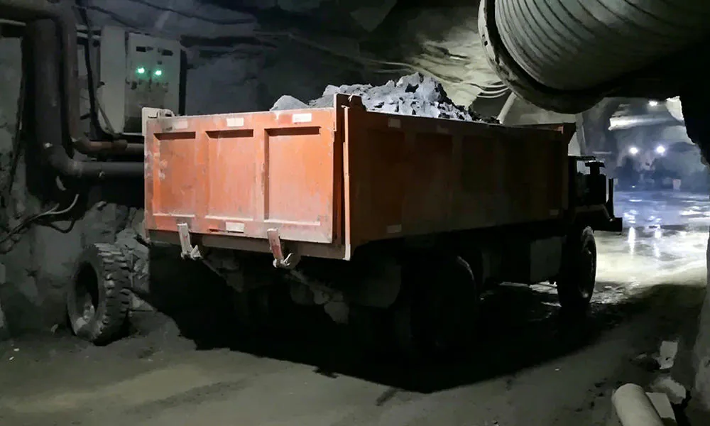 A dump truck inside a dimly lit underground passage.