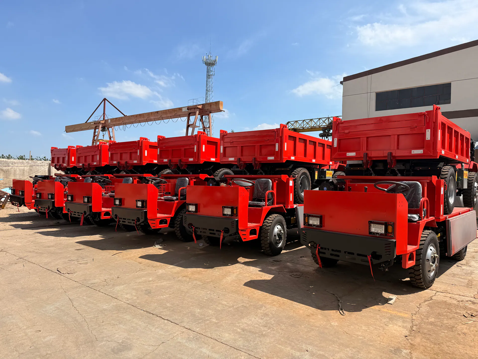 Red mining trucks arranged outdoors for export preparation.