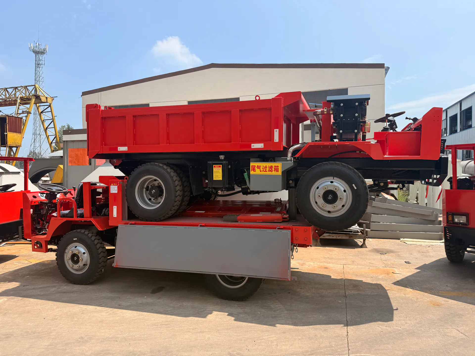A red mining truck positioned on a transport platform.